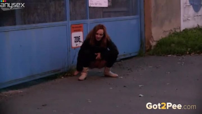 Kinky shameless redhead squats down to piss outdoors on the grass